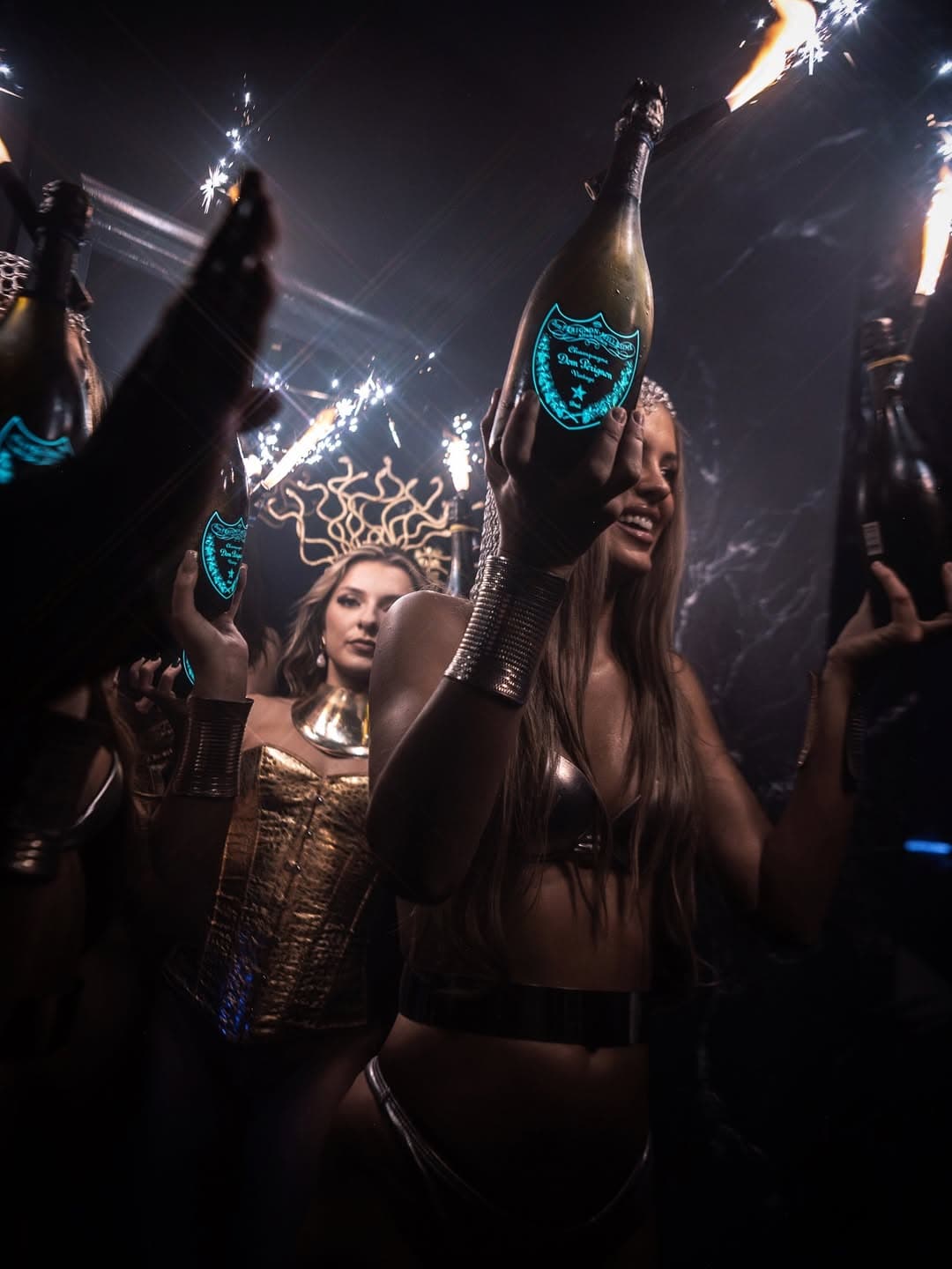 Selene Club bottle girls carrying champagne bottles to a table